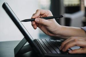 Aziatisch collega's Mens en vrouw bespreken en werken met laptop computer Aan kantoor bureau in de kantoor foto