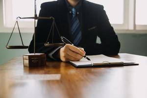 zaken en advocaten bespreken contractpapieren met koperen schaal op bureau in kantoor. wet, juridische diensten, advies, rechtvaardigheid en wet concept foto met film grain effect