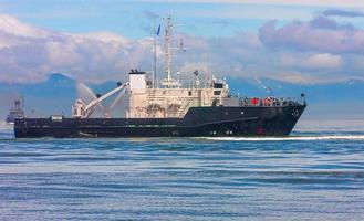 klein schip Bij blauw zee in de buurt de kust foto