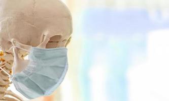 menselijke schedel in eenvoudig dun medisch masker voor bescherming tegen virale infectie foto