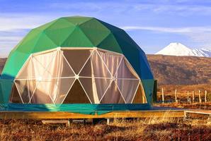 groen geo-dome tent Aan kamchatka schiereiland. knus, camping, glamperen, vakantie, vakantie levensstijl concept. buitenshuis cabine, toneel- achtergrond foto