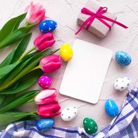 gelukkig ester. kleur eieren met tulpen en gifs Aan grijs achtergrond top visie foto