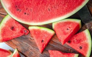 dichtbij omhoog van smakelijk gesneden vers watermeloen Aan een houten hakken bord foto