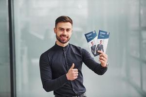 zakenman Holding twee brochures foto