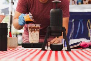 barista gieten espresso schot in een glas van verkoudheid vers melk. foto