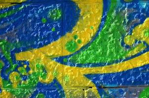 fragment van graffiti tekeningen. de oud muur versierd met verf vlekken in de stijl van straat kunst cultuur. gekleurde achtergrond structuur in groen tonen foto