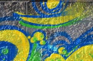 fragment van graffiti tekeningen. de oud muur versierd met verf vlekken in de stijl van straat kunst cultuur. gekleurde achtergrond structuur in groen tonen foto