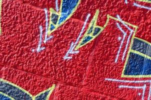 fragment van graffiti tekeningen. de oud muur versierd met verf vlekken in de stijl van straat kunst cultuur. gekleurde achtergrond structuur in warm tonen foto