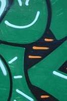 fragment van graffiti tekeningen. de oud muur versierd met verf vlekken in de stijl van straat kunst cultuur. gekleurde achtergrond structuur in groen tonen foto