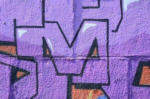 fragment van graffiti tekeningen. de oud muur versierd met verf vlekken in de stijl van straat kunst cultuur. gekleurde achtergrond structuur in Purper tonen foto
