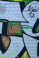 fragment van graffiti tekeningen. de oud muur versierd met verf vlekken in de stijl van straat kunst cultuur. gekleurde achtergrond structuur in groen tonen foto