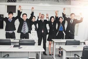 bedrijf mensen tonen hand- omhoog vieren na afgewerkt vergadering en congres in kantoor, succes en samenspel concept foto
