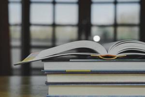 stack of plie van wijnoogst oud boeken Aan houten tafel. aan het leren, onderwijs en studie concept. een van hen Open met kopiëren ruimte. foto