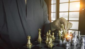 geconcentreerd zakenman ontwikkelen schaak gambiet, strategie , spelen bord spel naar winnaar knap concentratie en denken terwijl spelen schaken. aan het leren, tactiek en analyse concept. foto