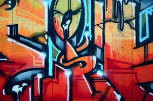 een fragment van gedetailleerd graffiti van een tekening gemaakt met aërosol verven Aan een muur van beton tegels. achtergrond beeld van straat kunst in warm rood kleur tonen foto