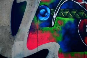 een fragment van gedetailleerd graffiti van een tekening gemaakt met aërosol verven Aan een muur van beton tegels. achtergrond beeld van straat kunst in verschillend kleuren foto