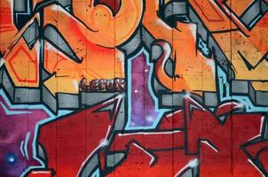een fragment van gedetailleerd graffiti van een tekening gemaakt met aërosol verven Aan een muur van beton tegels. achtergrond beeld van straat kunst in warm rood kleur tonen foto