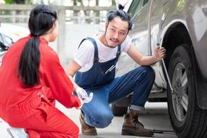 specialist mechanisch ingenieur gemaakt en reparatie voertuig of auto band lekken met zijn collega Aan weg voor mooi zo vervoer in de buurt garage foto