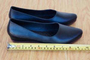 detailopname zwart schoenen voor vrouw en meten plakband. concept, meting grootte van schoenen. schoeisel. foto