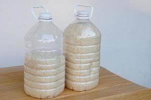 twee plastic flessen dat bevatten granen van rijst- naar voorkomen van stof of insecten. doe-het-zelf. concept, hergebruik plastic fles. nul afval. foto