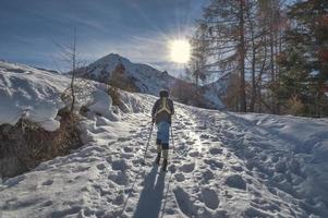 een kind bergop met zeehondenhuid onder zijn skis foto