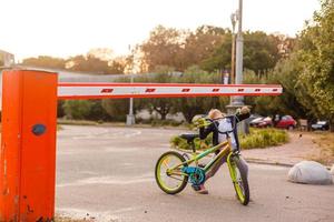 weinig meisje Aan een fiets fiets in de buurt de barrière foto