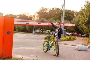 weinig meisje Aan een fiets fiets in de buurt de barrière foto