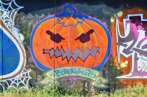 de oud muur, geschilderd in kleur graffiti tekening met aërosol verven. afbeelding van een onheil en eng oranje pompoen, bereid voor halloween foto