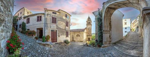 visie over- de geplaveide historisch toegang weg naar motovun met evangelisch kerk gedurende de dag foto