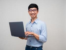portret Aziatisch zakenman gelukkig glimlach Holding laptop voor werken geïsoleerd foto