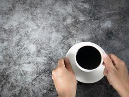 Mens hand- Holding zwart koffie kop donker achtergrond top visie foto