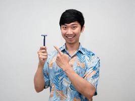 Aziatisch jong Mens glimlach en punt vinger Bij scheren in zijn hand- geïsoleerd foto