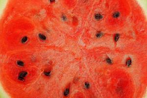 voor de helft van sappig, rood watermeloen Aan een wit achtergrond, structuur van sappig pulp en memes van rijp watermeloen foto