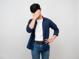Aziatisch Mens staan gebaar dichtbij zijn gezicht voelt hoofdpijn en depressief geïsoleerd foto