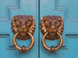 twee messing leeuw vormig deur klopper Aan houten deur foto