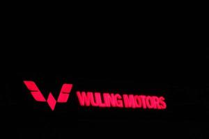 bekasi, Indonesië in juli 2022. de wuling motoren logo schijnend helder Bij nacht tegen de donker nacht lucht. foto