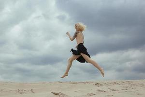 blond kaal dame rennen langs strand toneel- fotografie foto