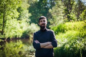 portret van een man bij zonsondergang. mannelijk model in het bos foto