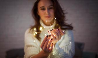 brunette vrouw Toneelstukken met slinger van fee lichten foto