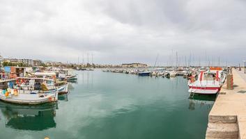 panoramisch afbeelding van rethimnon haven met promenade en vuurtoren in zomer foto