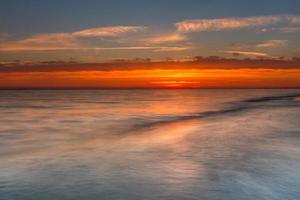 patronen in de zee zand Bij zonsondergang foto