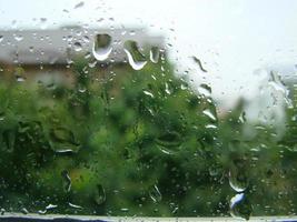 regenachtig dagen regen druppels Aan de venster oppervlakte foto