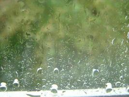 regenachtig dagen regen druppels Aan de venster oppervlakte foto