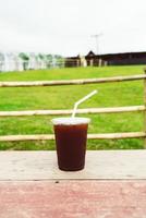 americano koffie Aan hout tafel met berg heuvel visie achtergrond foto