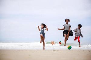 groep van kinderjaren vrienden jumping gelukkig Aan een tropisch strand. etnisch verschillend concept foto