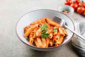 penne pasta met tomaat sausen in bord Aan steen achtergrond tafel. detailopname. Italiaans voedsel foto