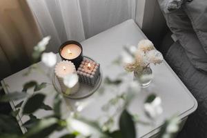 huis aroma geur verdeler en brandend kaarsen Aan nachtkastje tafel in de slaapkamer. knus humeur concept foto
