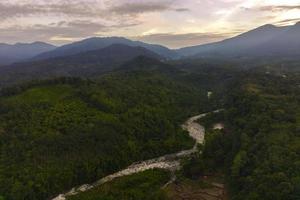 mooi ochtend- visie van Indonesië. antenne foto van rivier- tussen bergen en tropisch Woud