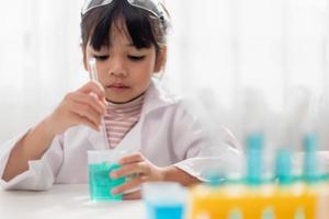 opleiding, wetenschap, chemie en kinderen concept - kinderen of studenten met test buis maken experiment Bij school- laboratorium foto