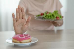 mooi zo Gezondheid voedsel en eetpatroon. Dames afwijzen rommel voedsel of ongezond voedingsmiddelen zo net zo donuts en Kiezen gezond voedingsmiddelen zo net zo groen appel. foto